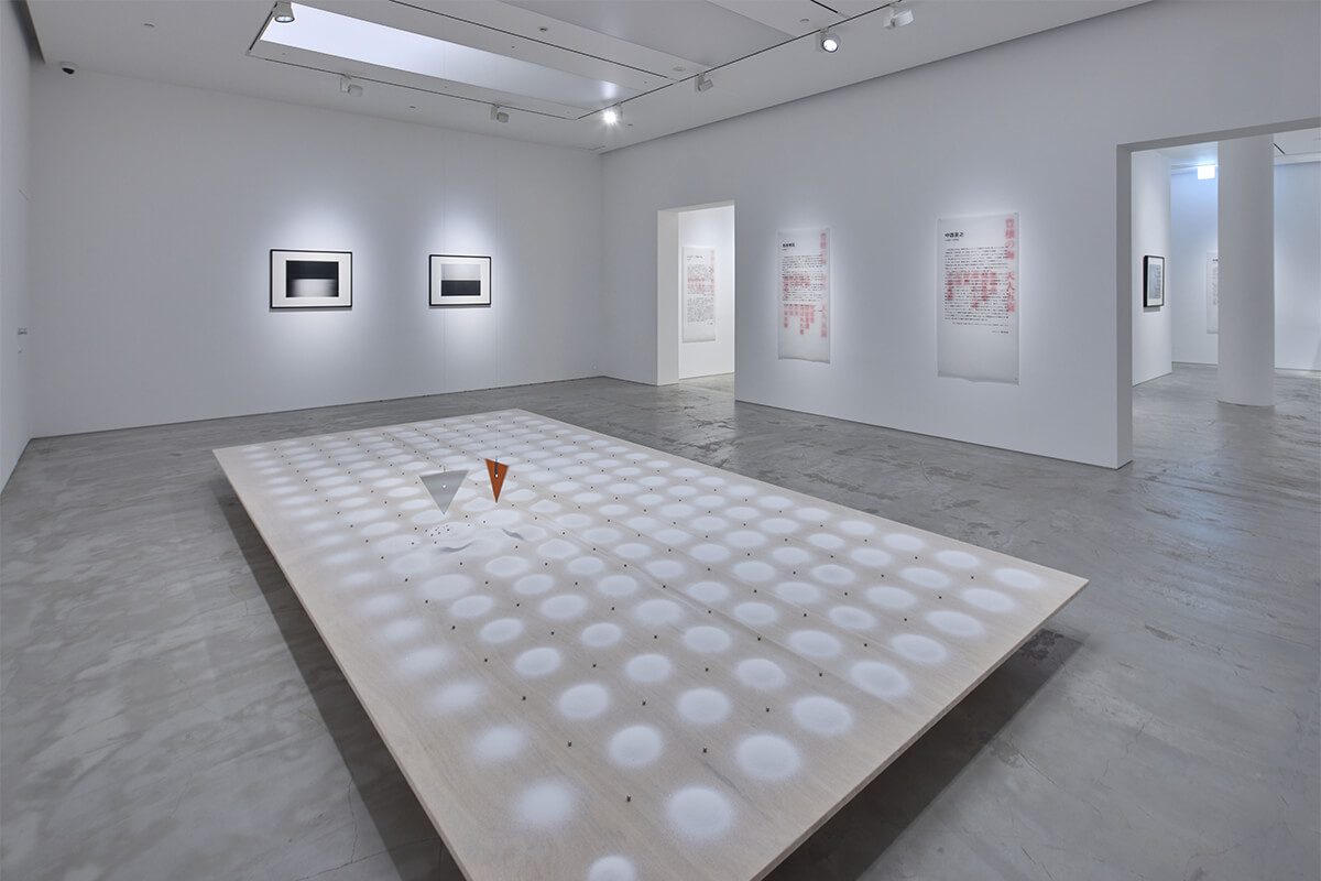 『永劫回帰に横たわる虚無』展の展示風景の画像。手前の作品は中西夏之『着陸と着水』。奥は杉本博司『相模湾、江之浦』。