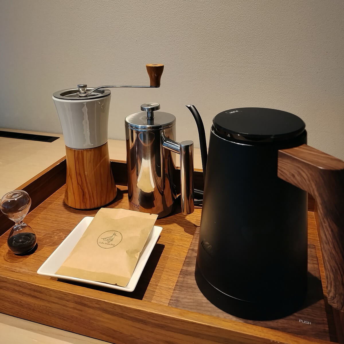 コーヒー豆と、コーヒーミルやフレンチプレスのドリッパーが用意されている画像