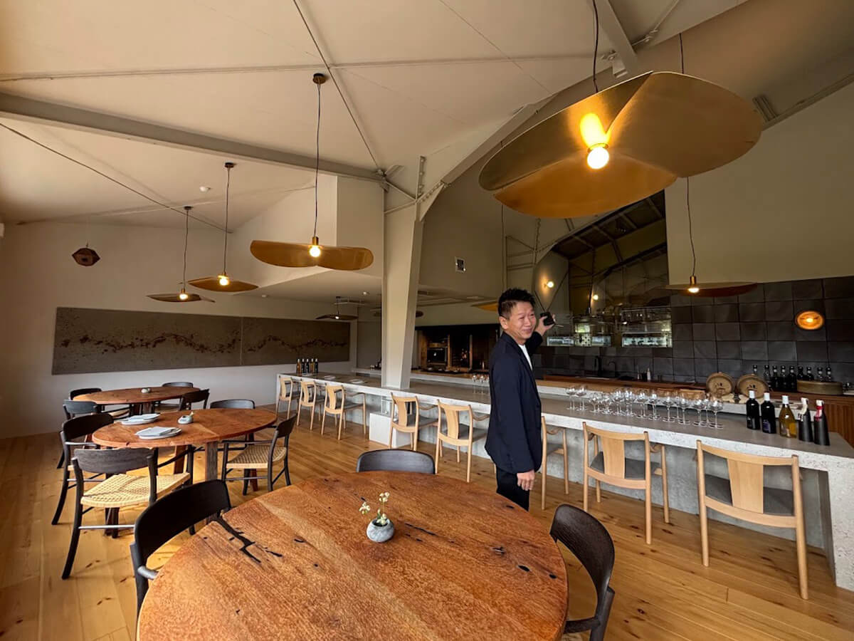 カウンターとテーブル席があり、オープンキッチンのスタイルの画像