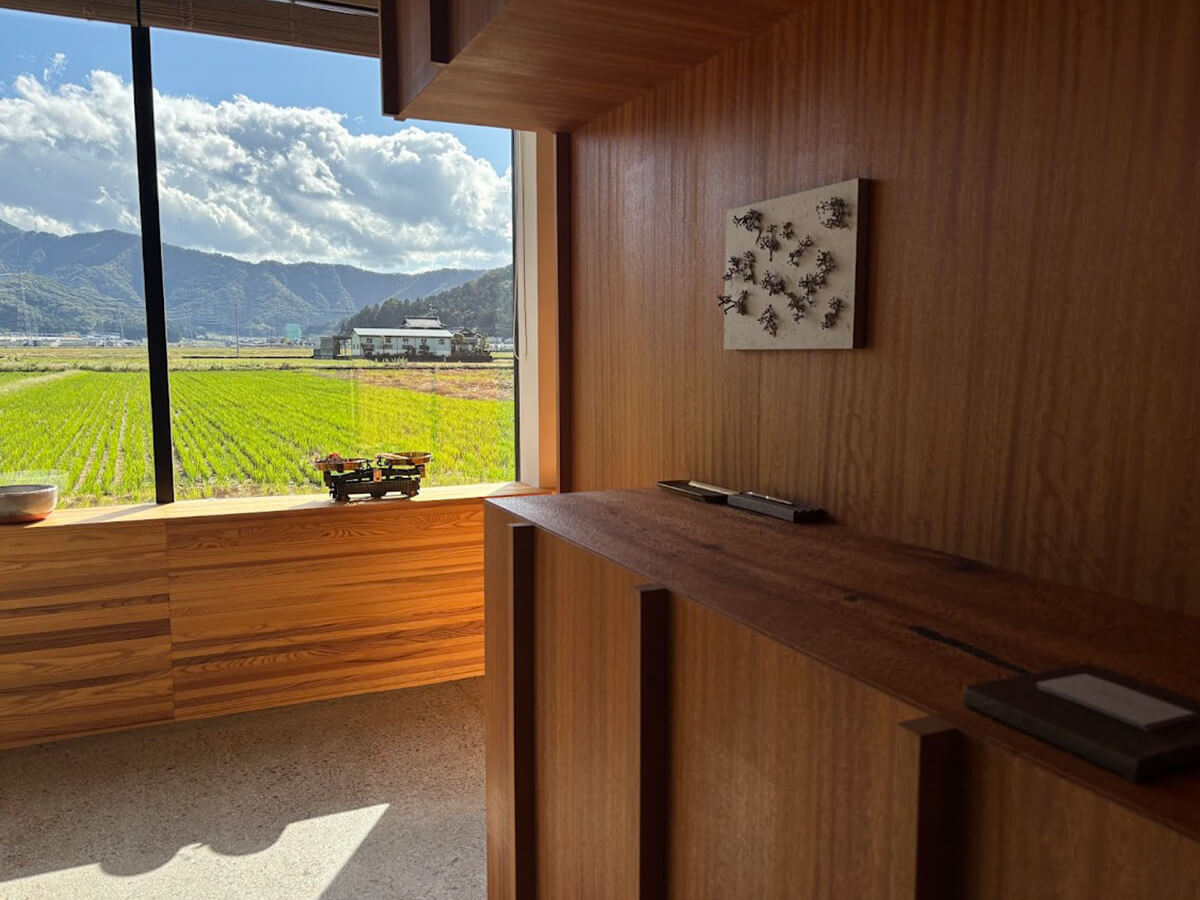 窓から長閑な田園風景が望めるスタイリッシュなダイニングの入口の画像