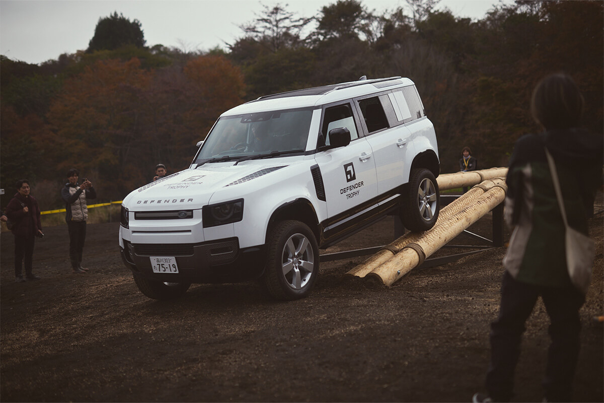 丸太を組んでディフェンダーが走行できる橋を組み走行する競技の画像