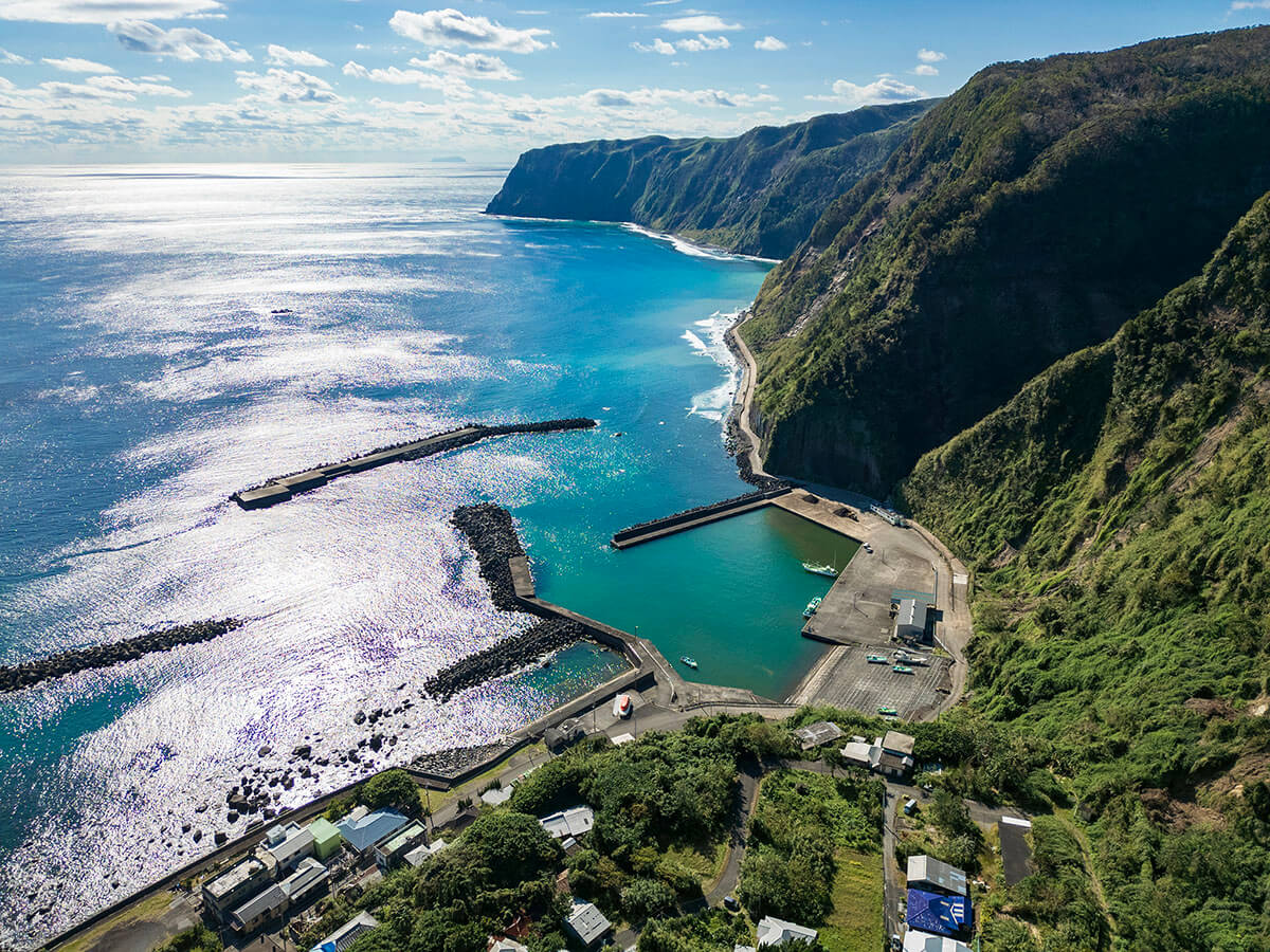 日が海に差し込むとエメラルドグリーンに見える、島の南部の海岸線の画像