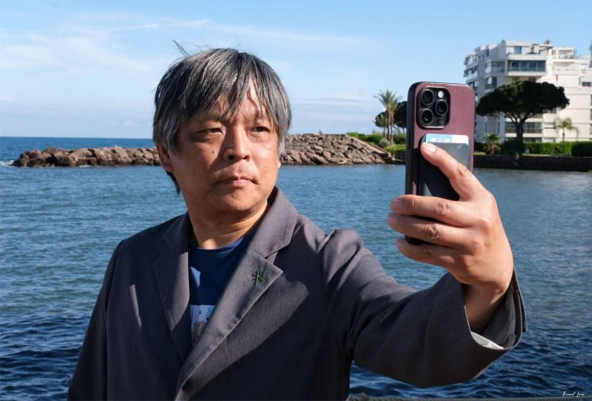 スマホ1つを持って、世界へと旅立つ赤松氏の画像