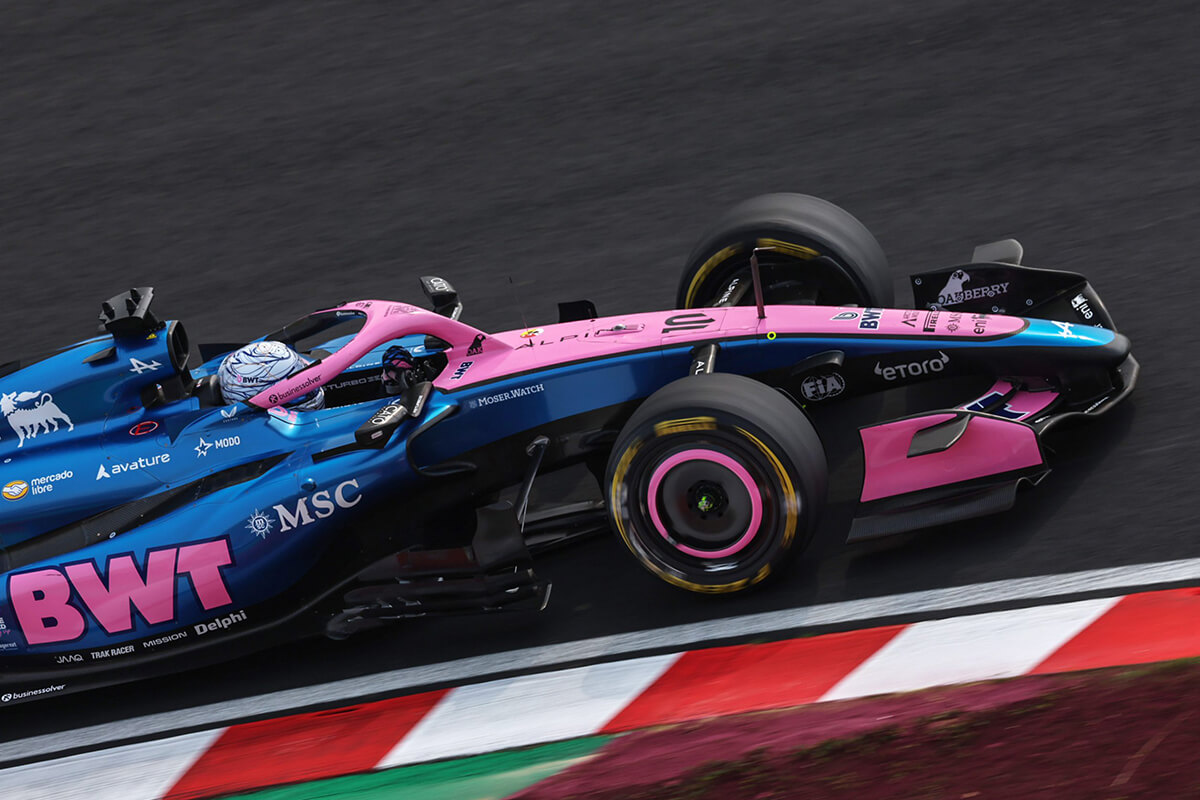 ブルーとピンクの車体が鈴鹿サーキットを走り抜ける画像